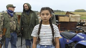 Kiawentiio as Beans with militia in the background